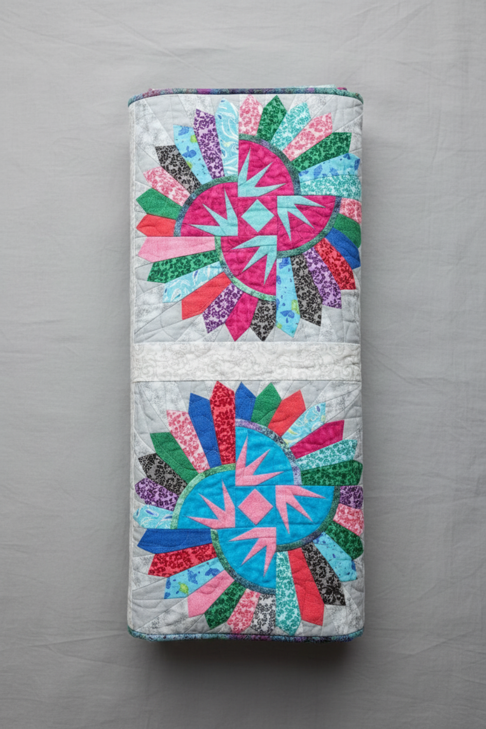 Colorful quilt with geometric patterns on a gray background