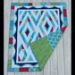 Prism quilt showing front geometric design and coordinating patchwork backing