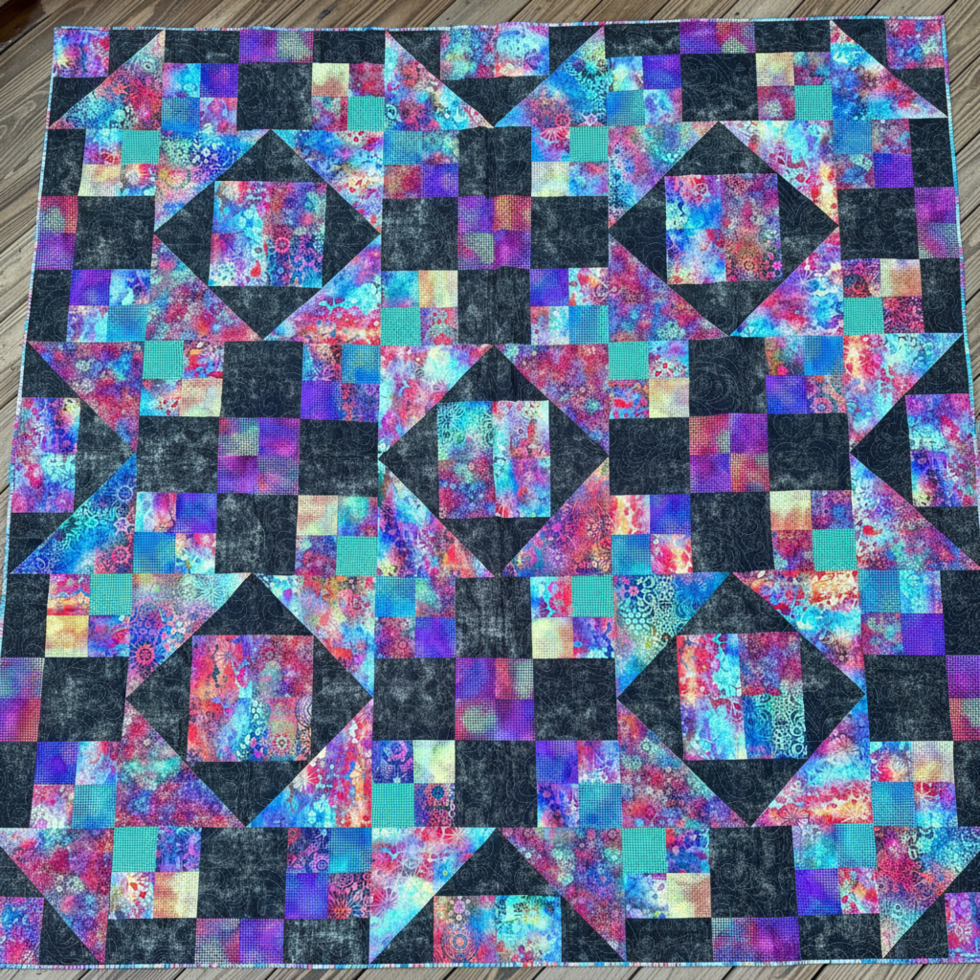 Handmade Jewels of the Night quilt laid flat showing jewel-toned patchwork design