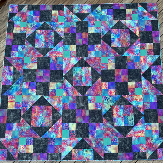 Handmade Jewels of the Night quilt laid flat showing jewel-toned patchwork design