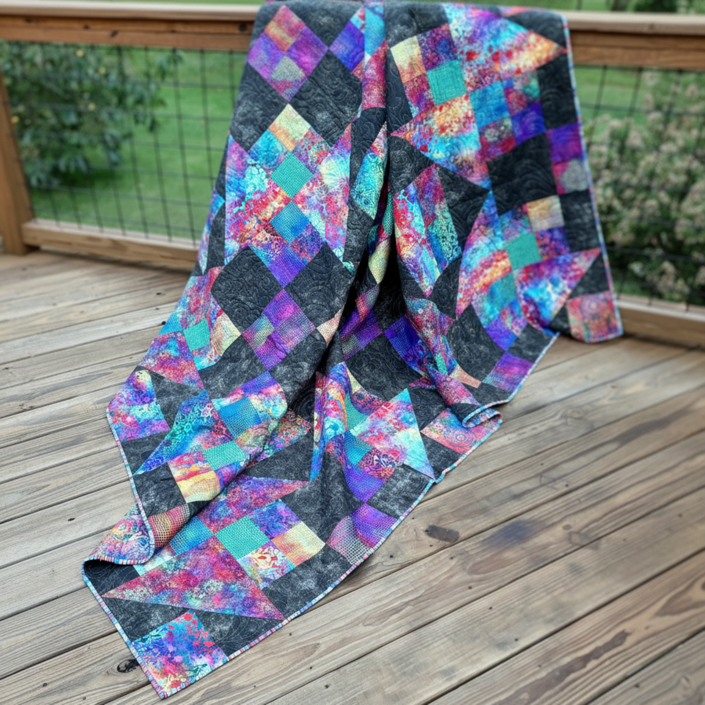 Jewels of the Night handmade quilt draped outdoors highlighting bold colors