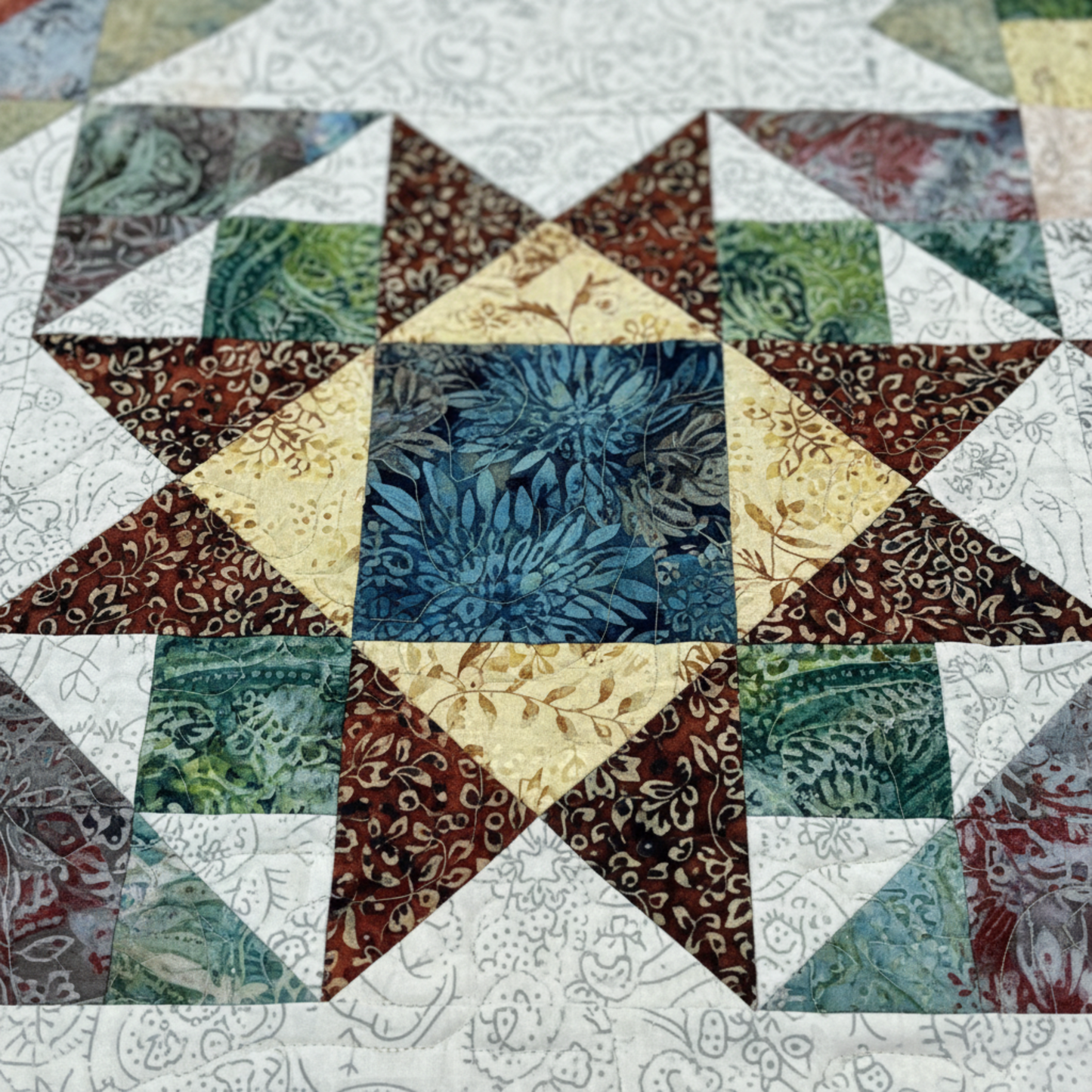 Close-up of Windsong quilt featuring traditional pieced blocks and batik fabrics