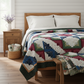 Log Cabin Star handmade quilt styled on twin bed with classic bedroom decor