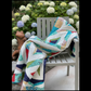 Colorful geometric Prism quilt draped over patio chair in natural light