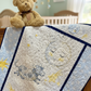 Quilt with animals and teddy bear in a nursery.