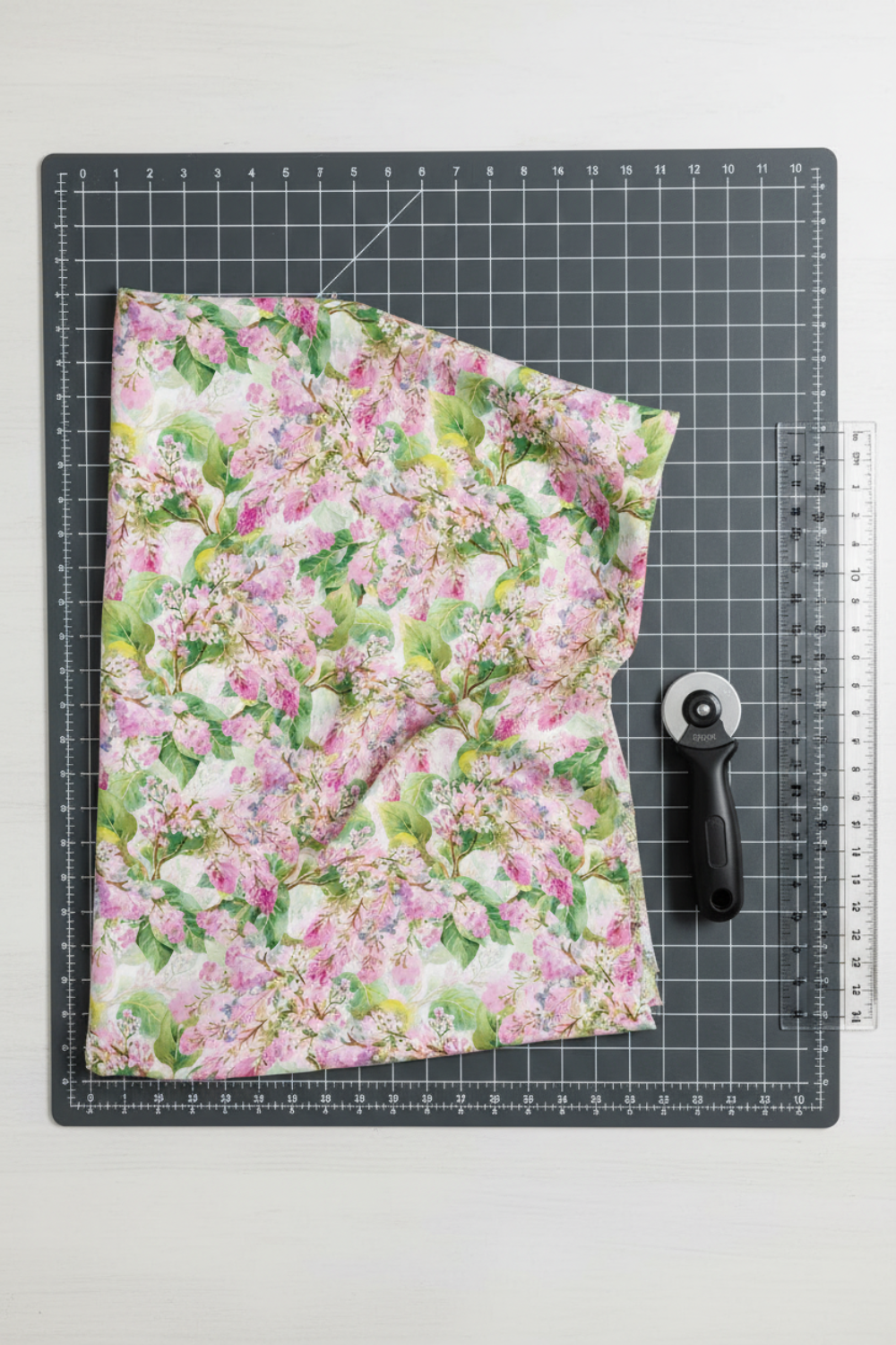 Decoupage Lilac Pink quilting cotton styled on cutting mat with ruler and rotary cutter – quilt planning lifestyle photo