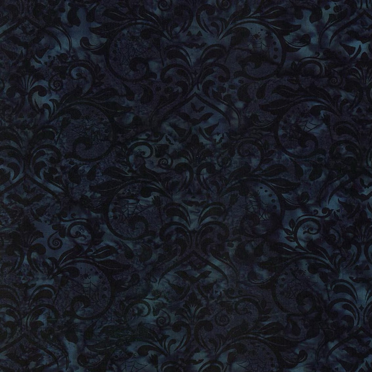 Close-up of Whispering Hollows Raven batik fabric by Riley Blake Designs, showing swirling damask motifs and subtle teal-blue mottling across a deep navy-black ground.