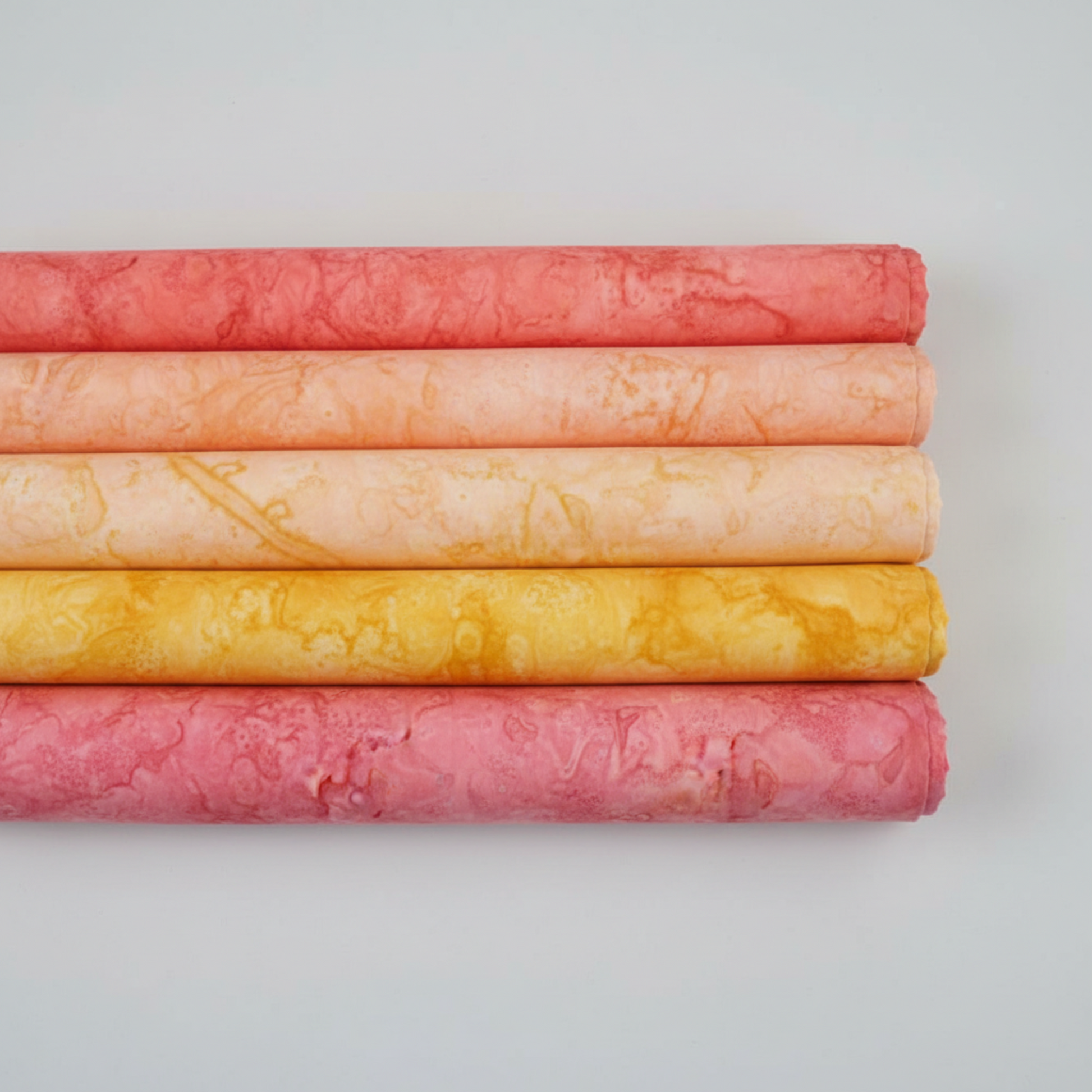 Expressions Batiks Hand-Dyed Sunset quilting cotton by Riley Blake Designs – coordination stack of 5 complementary quilting fabrics stacked on light grey background, clean minimal composition