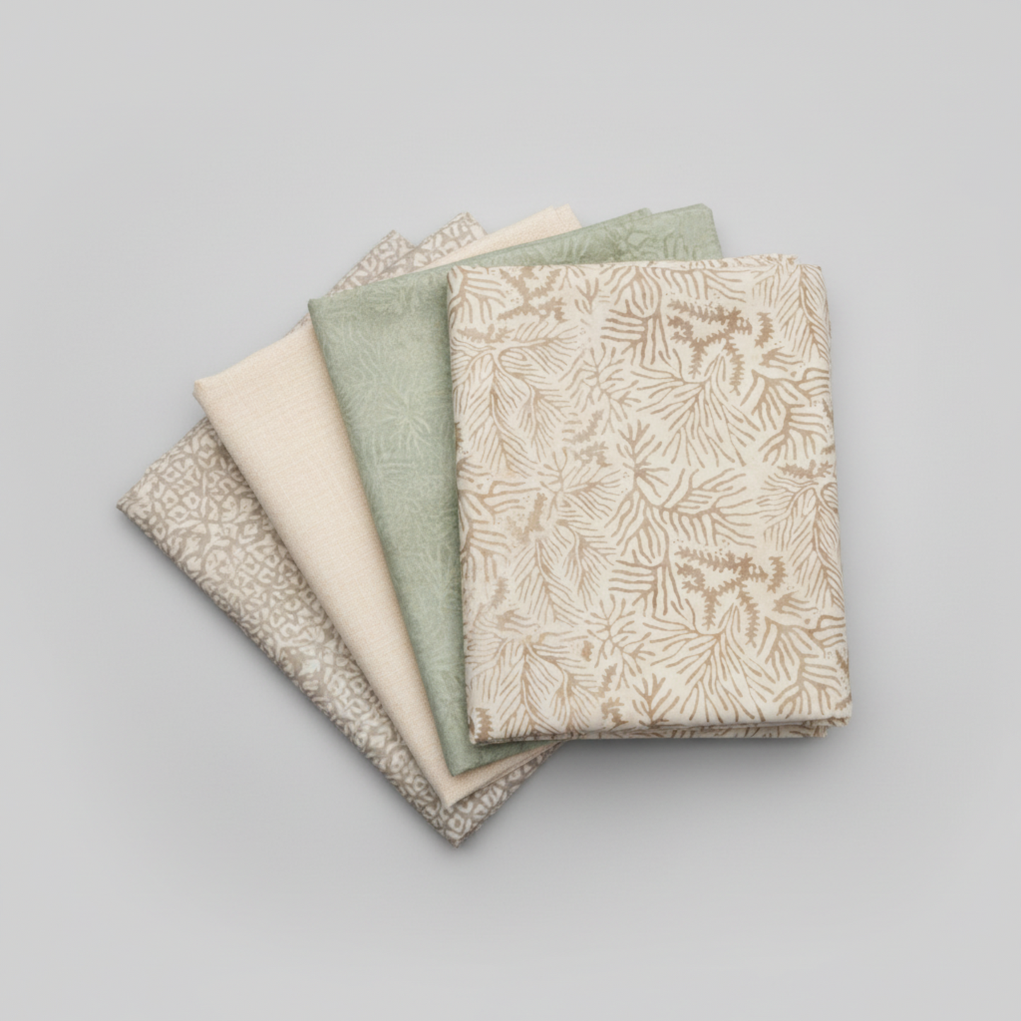 Expressions Batiks Breathe Ecru quilting cotton by Riley Blake Designs – coordination fan stack of 4 folded fabrics fanned on light grey background: cream ecru pine needle batik on top, soft sage green tonal batik, solid warm cream, and taupe-grey small geometric batik on bottom