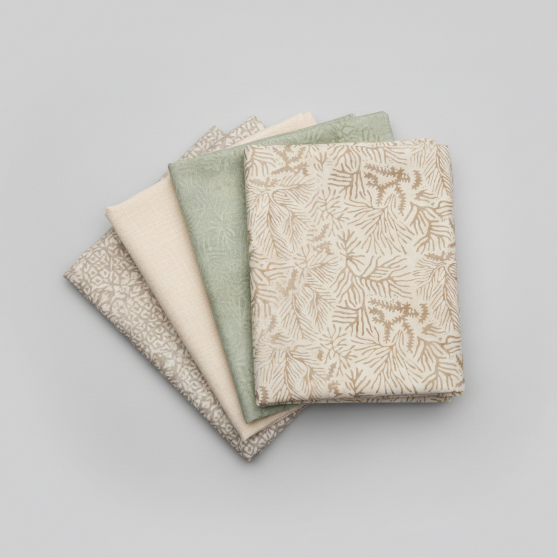 Expressions Batiks Breathe Ecru quilting cotton by Riley Blake Designs – coordination fan stack of 4 folded fabrics fanned on light grey background: cream ecru pine needle batik on top, soft sage green tonal batik, solid warm cream, and taupe-grey small geometric batik on bottom