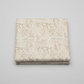Expressions Batiks Breathe Ecru quilting cotton fabric by Riley Blake Designs – single neatly folded yard on light grey background showing warm cream and ecru tonal batik with all-over pine needle and feathery frond motif in soft taupe and golden-beige