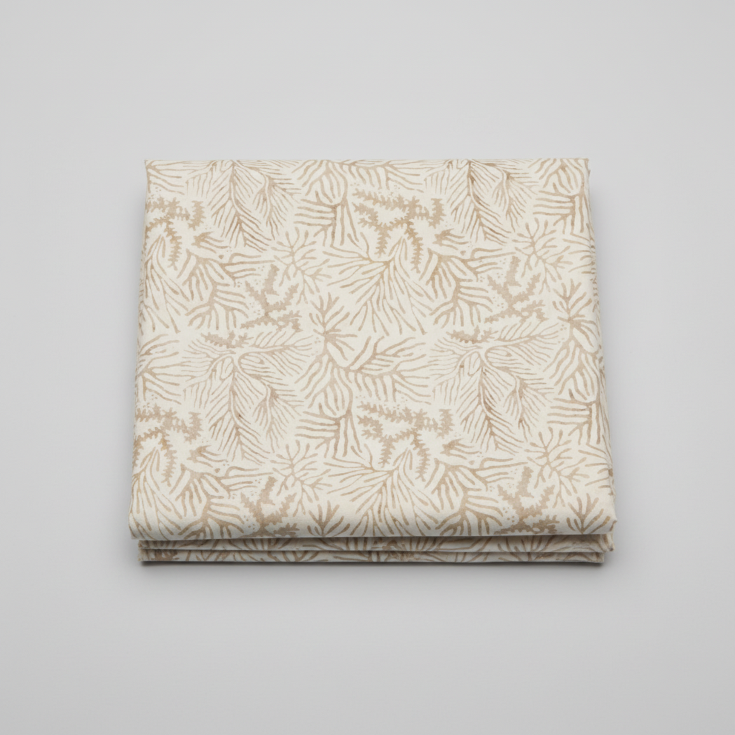 Expressions Batiks Breathe Ecru quilting cotton fabric by Riley Blake Designs – single neatly folded yard on light grey background showing warm cream and ecru tonal batik with all-over pine needle and feathery frond motif in soft taupe and golden-beige