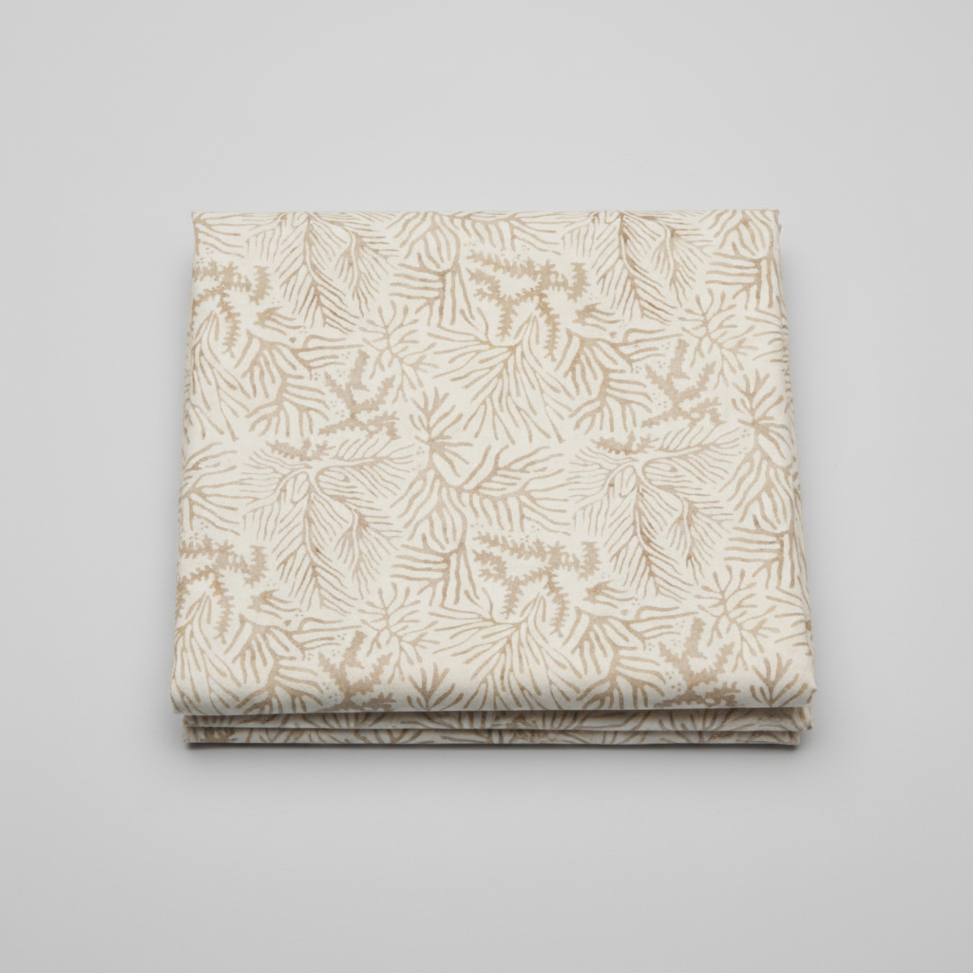 Expressions Batiks Breathe Ecru quilting cotton fabric by Riley Blake Designs – single neatly folded yard on light grey background showing warm cream and ecru tonal batik with all-over pine needle and feathery frond motif in soft taupe and golden-beige