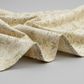 Expressions Batiks Breathe Laurel quilting cotton by Riley Blake Designs – Pinterest drape shot, soft accordion pleated folds filling portrait frame showing natural drape and movement, cream and ivory tonal batik with feathery fronds and dotted swirl outlines in soft sage green and warm taupe, light grey background