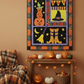 Halloween-themed wall art with pumpkins, witch boots, and a 'BOO' sign on a brown wall.