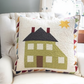 Decorative pillow with house design on a couch