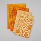 Expressions Batiks Hand-Dyes quilting cotton fabrics including Curry – 6 coordinating fabrics in complementary warm tones slightly fanned on light grey background