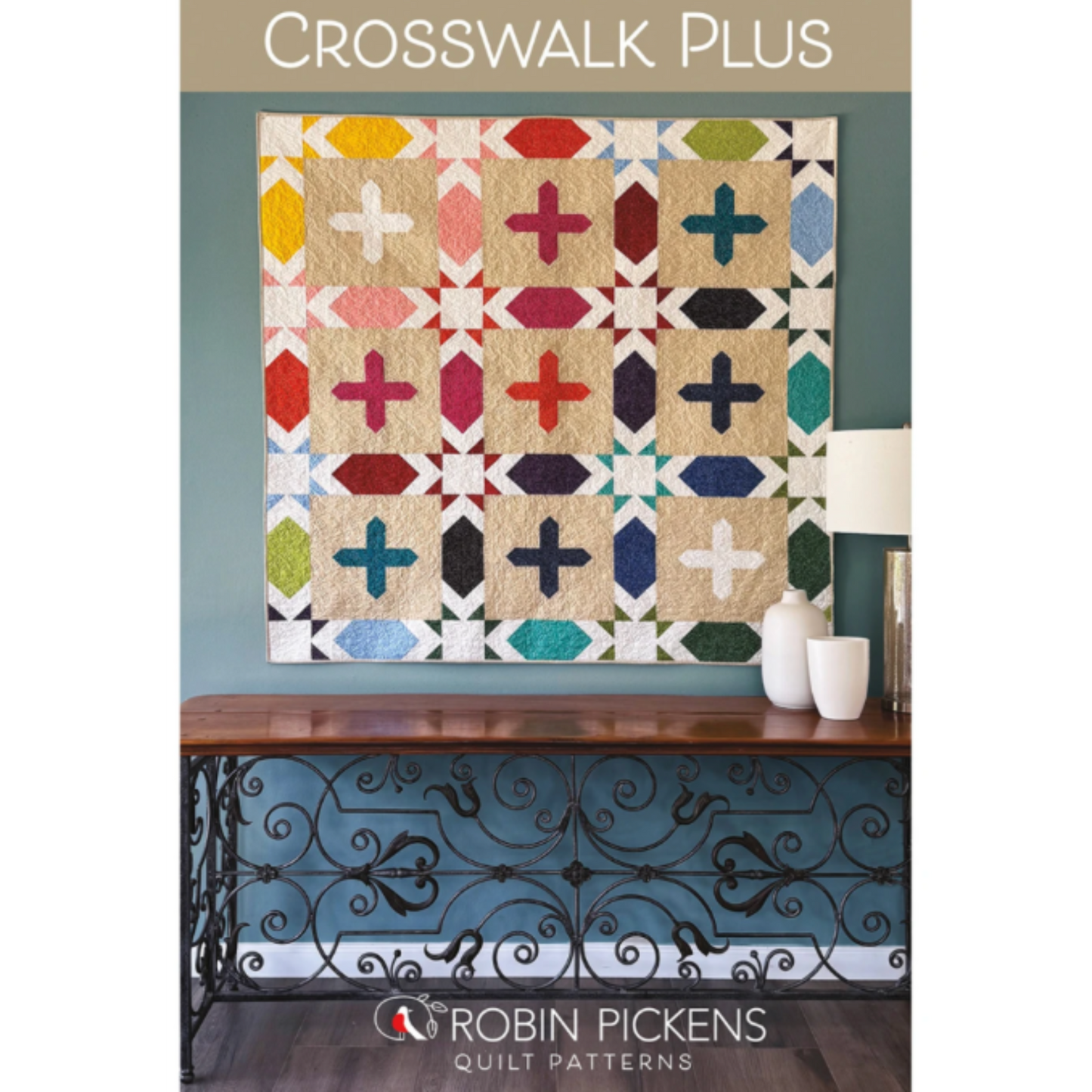 Crosswalk Plus quilt pattern by Robin Pickens — colorful plus blocks and open star elements displayed as wall art above a console table