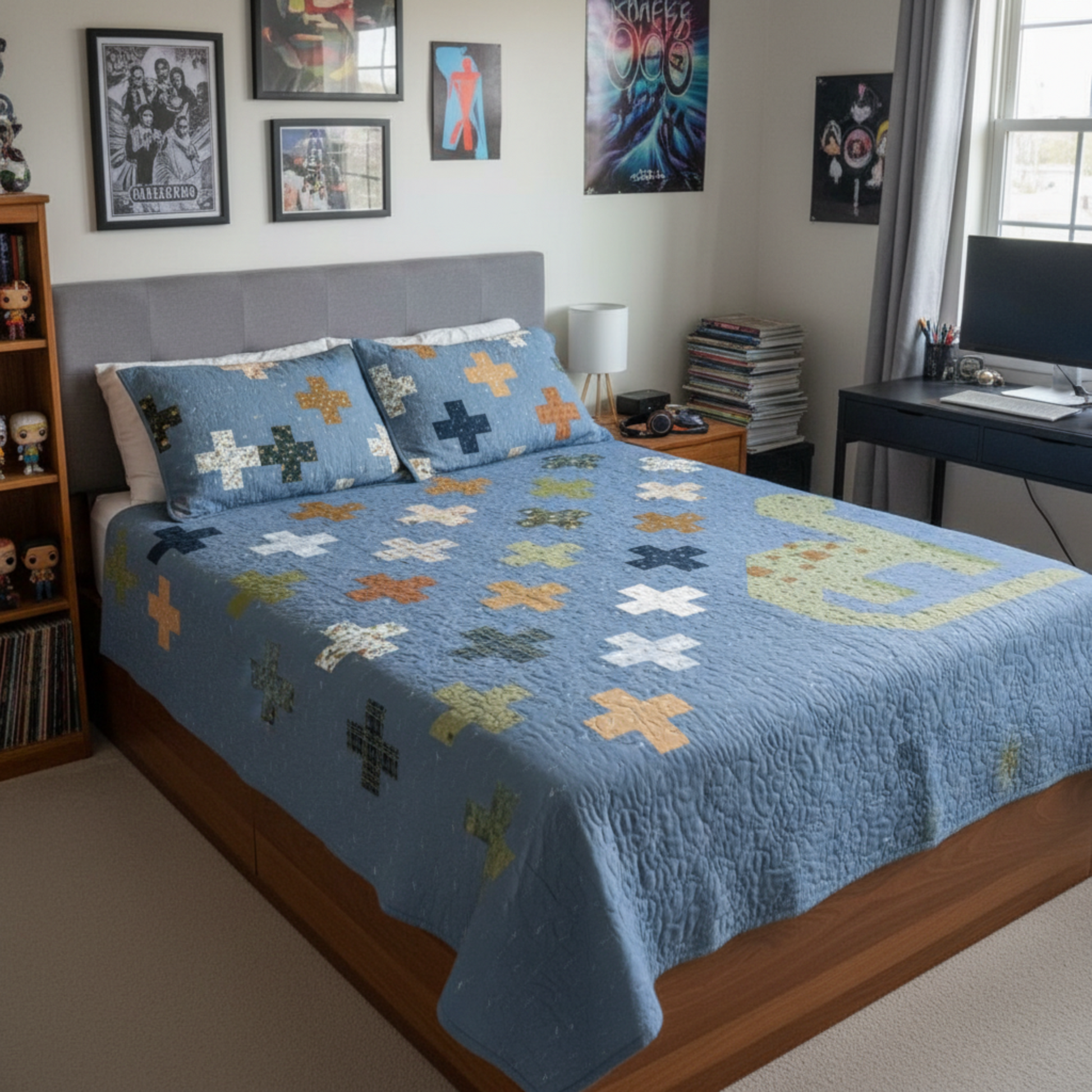 Bedroom with a bed covered in a blue quilt with colorful patterns, surrounded by posters on the wall.