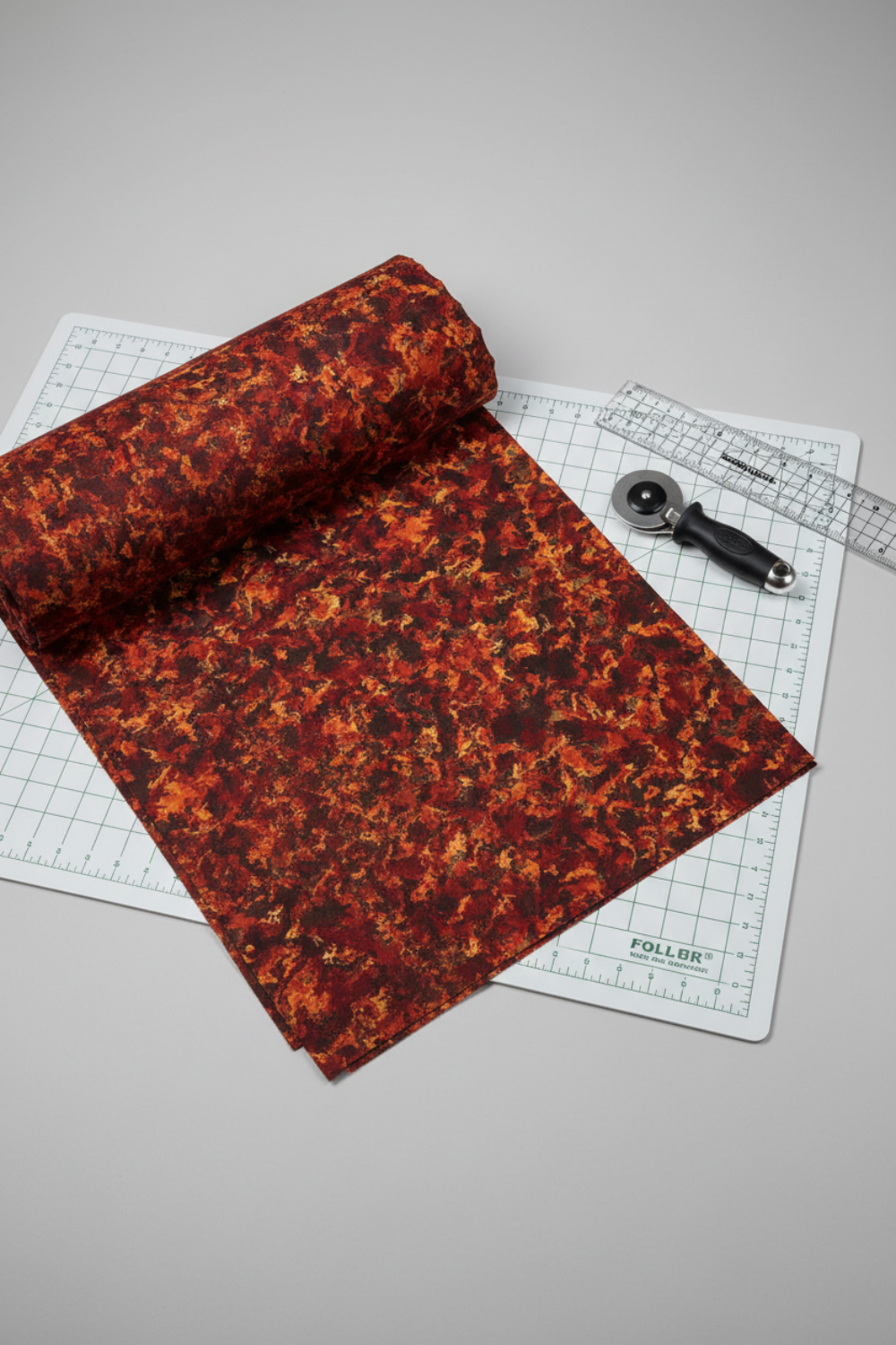 A Year of Art Autumn Texture quilting cotton styled on cutting mat with ruler and rotary cutter – quilt planning lifestyle photo