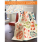 Hopscotch Happy quilt pattern cover by Robin Pickens — colorful HST quilt draped over red Barcelona chair, 4 sizes: lap, twin, queen and king, Layer Cake, Charm Pack or Fat Quarter friendly