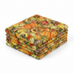 Autumn vegetable quilting fabric with pumpkins and berries in warm seasonal tones, shown from an angled view.