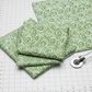 Detailed view of Winter Solstice II Green on White Snow Swirl cotton fabric highlighting elegant swirls