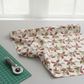 Winter Solstice II Cream Poinsettia Metallic quilting cotton folded stack showing fabric body and drape quality