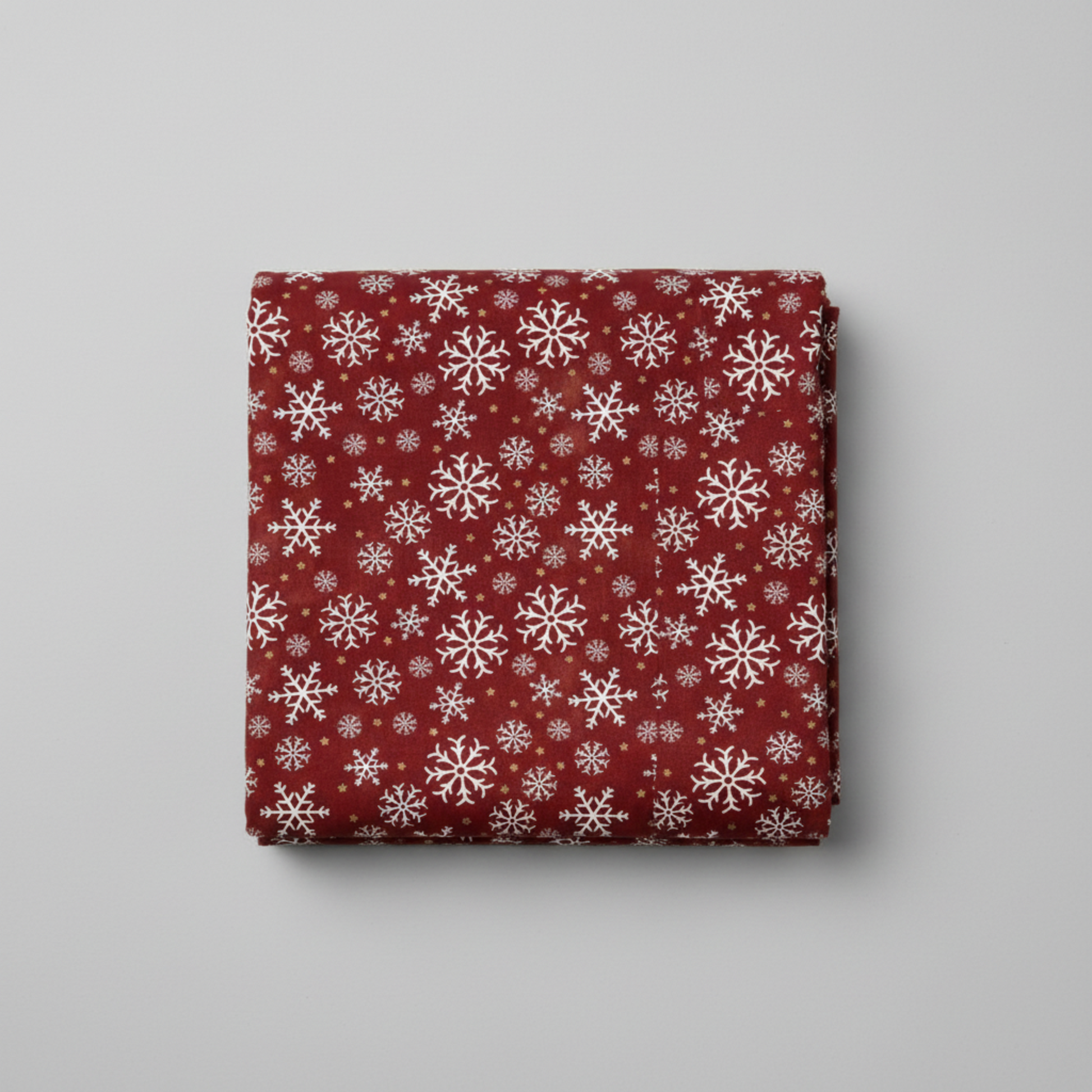 Winter Solstice II Red Snowflakes Metallic quilting cotton folded stack showing fabric body and drape quality