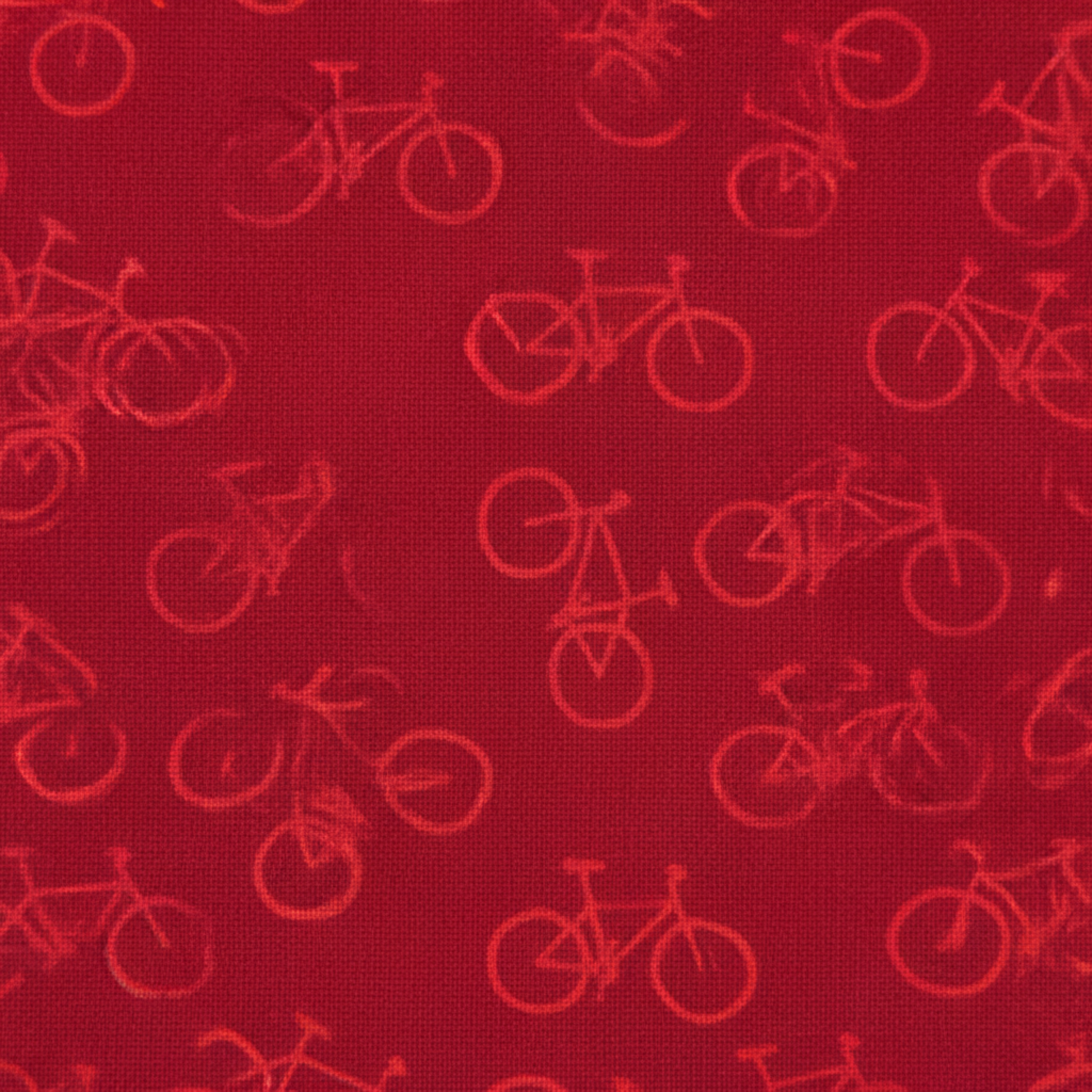 Close-up detail of On the Go Bicycles Red quilting cotton fabric highlighting whimsical bicycle illustration