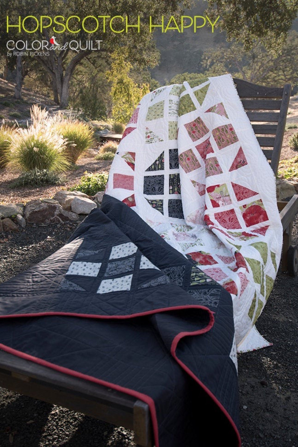 Hopscotch Happy quilt pattern Color and Quilt edition by Robin Pickens — dark navy lap quilt and light botanical colorway displayed outdoors on wooden bench! Shop at IraRobi Quilts! #QuiltPattern #RobinPickens #LayerCake #ModernQuilt #ColorAndQuilt