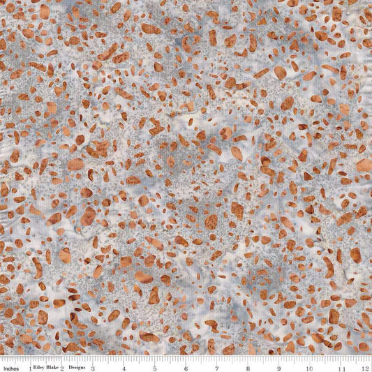 Terrazzo Coastal Path fabric by Riley Blake Designs — rust-orange terrazzo speckles on a soft gray and cream hand-dyed batik, shown with a ruler for scale.