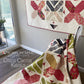 Criss Cross Kisses quilt pattern by Robin Pickens — lap version on wall and green colorway draped over silver chair showing two stunning colorways! Shop at IraRobi Quilts! #QuiltPattern #RobinPickens #XBlock #FatEighth #ModernQuilt