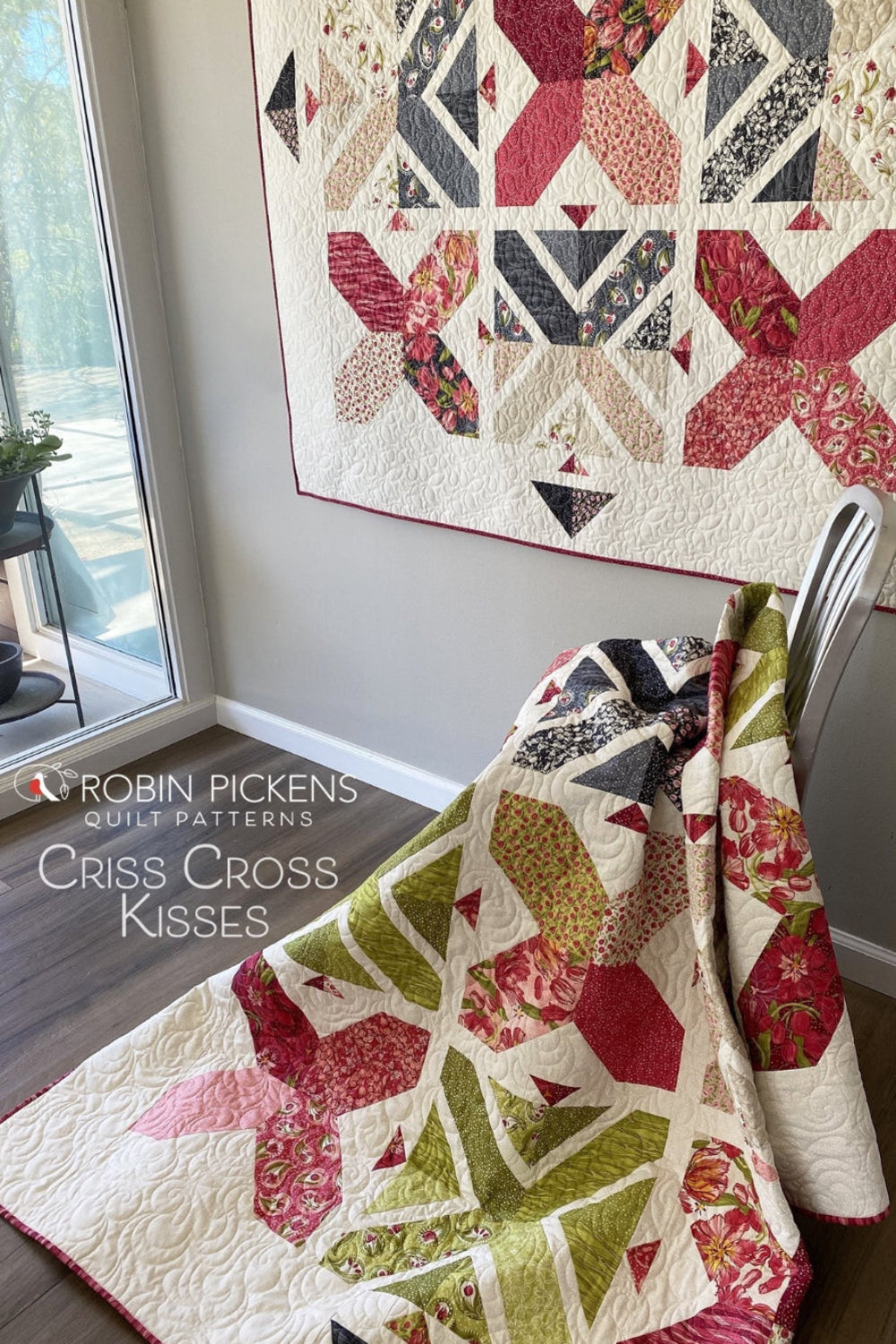 Criss Cross Kisses quilt pattern by Robin Pickens — lap version on wall and green colorway draped over silver chair showing two stunning colorways! Shop at IraRobi Quilts! #QuiltPattern #RobinPickens #XBlock #FatEighth #ModernQuilt