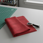 Interwoven Red quilting cotton fabric from the Interwoven collection, vibrant red geometric pattern draped on green cutting mat with rotary cutter for scale