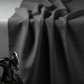 Interwoven Dark Slate by Jason Yenter – soft cascading drape showing fabric body and hand, light grey background, partial sewing machine edge visible