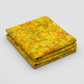Expressions Batiks Hand-Dyed Yellow Orange Multi 3 quilting cotton fabric by Riley Blake Designs – vivid multicolor hand-dyed batik neatly folded in 3 folds on light grey background showing golden yellow, warm orange, and olive green palette