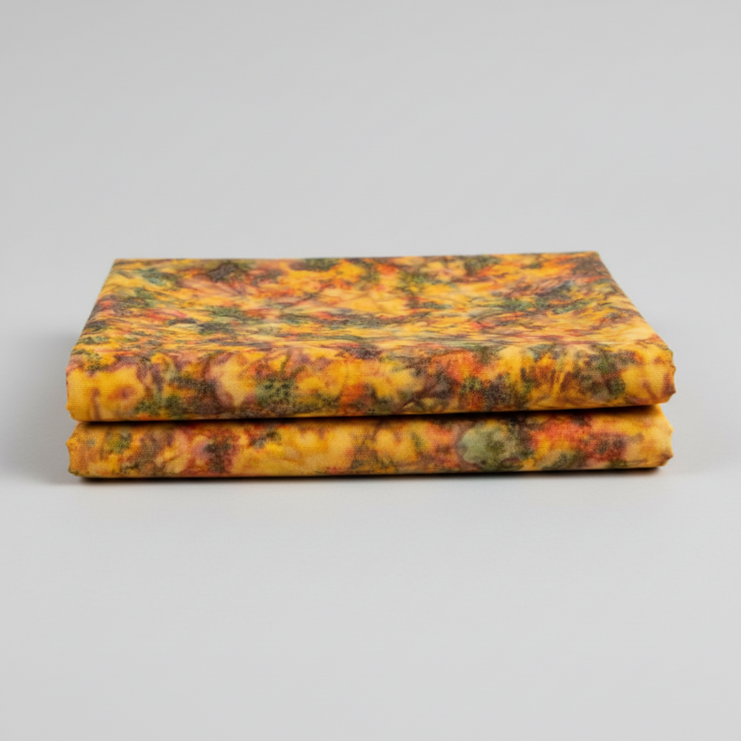 Expressions Batiks Hand-Dyed Orange Multi I quilting cotton fabric by Riley Blake Designs – 2 neatly folded yards stacked on light grey background showing complex multicolor hand-dyed batik with golden amber-orange, olive green, slate blue-grey, and red-orange palette