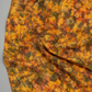 Expressions Batiks Hand-Dyed Orange Multi I quilting cotton fabric by Riley Blake Designs – Pinterest drape shot, soft gathered folds filling frame showing full surface texture of complex multicolor hand-dyed batik with golden amber-orange, olive green, red-orange, and muted brown-grey palette