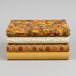 Expressions Batiks Hand-Dyed Orange Multi I quilting cotton by Riley Blake Designs – Pinterest coordination stack of 4 folded fabrics stacked vertically on light grey background: amber-orange multicolor batik on top, cream small floral vine print, rust orange hexagon geometric, and golden mustard yellow solid