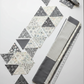 Interwoven Slate by Jason Yenter – Pinterest overhead layout of cut triangles with rotary cutter, clean quilt-in-progress flat lay on light grey background