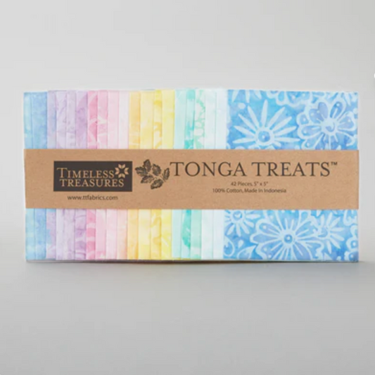 Tonga Batik Pixie by Timeless Treasures – Tonga Treats charm pack of 42 pre-cut 5" squares showing full pastel rainbow palette from soft lavender and blush pink through pale yellow, mint, aqua, and sky blue hand-dyed batik with daisy motif detail