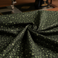 Vintage Charm Green Flower Patch by Judie Rothermel for Marcus Fabrics – draped black cotton reproduction fabric showing green ditsy floral print texture, styled with antique sewing machine