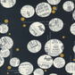 Close-up of Celestial News Dropping Onyx by Zen Chic for Moda – cream vintage newspaper circles and gold metallic dots on black 100% cotton quilting fabric