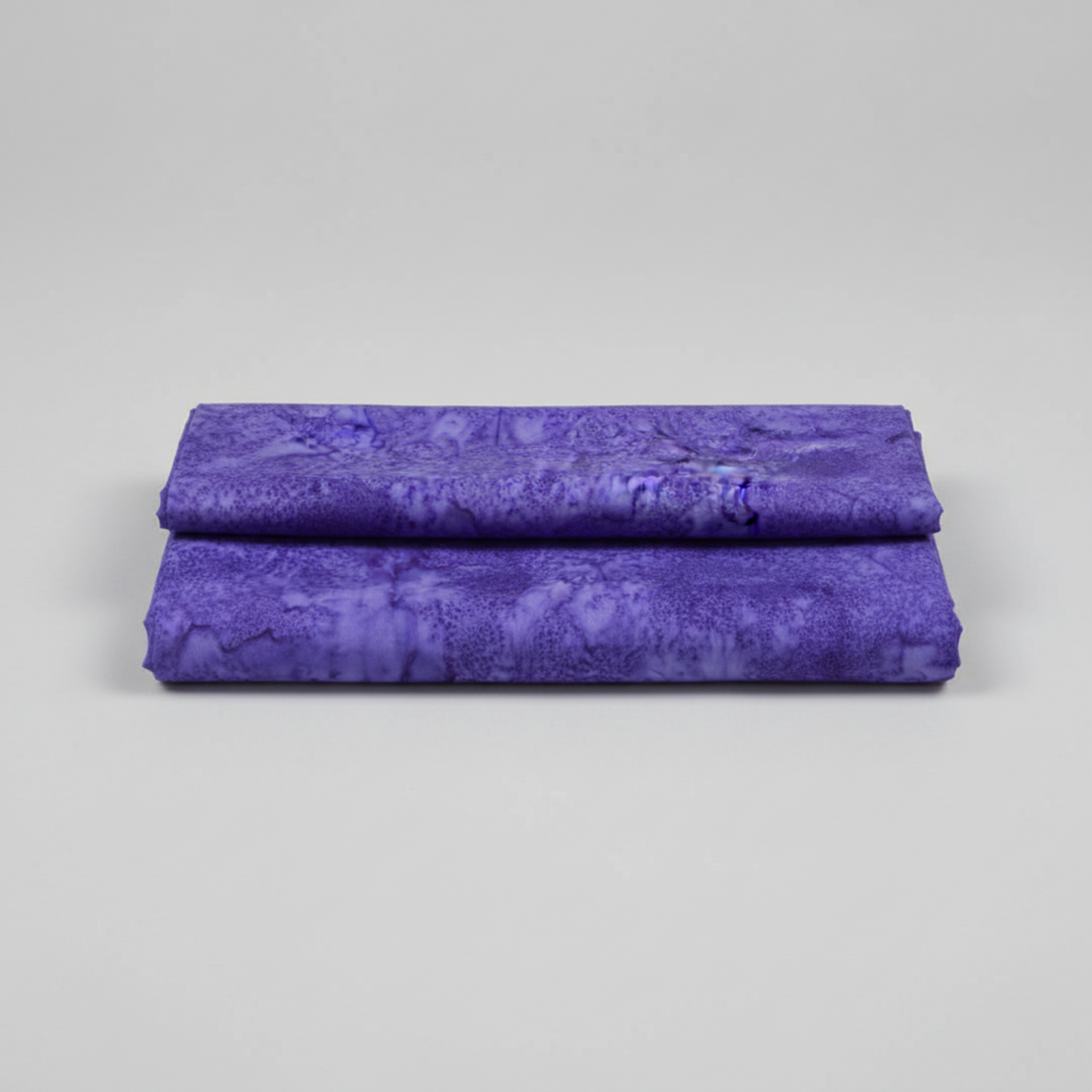 Expressions Batiks Hand-Dyed Purple II – hero flat lay, rich purple hand-dyed batik quilting cotton centered on light grey background, Riley Blake Designs