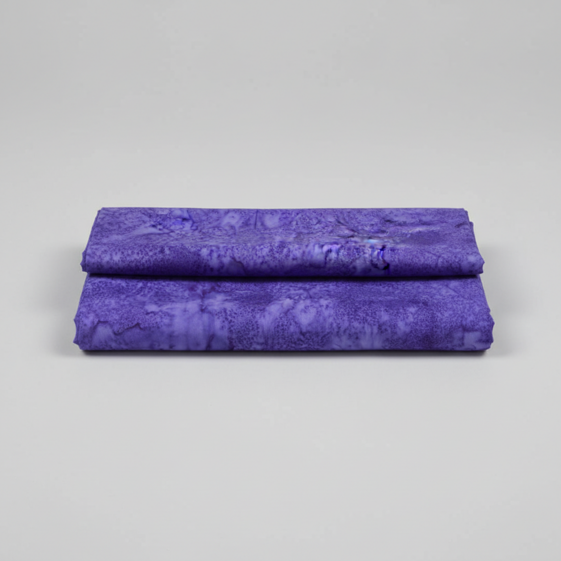 Expressions Batiks Hand-Dyed Purple II – hero flat lay, rich purple hand-dyed batik quilting cotton centered on light grey background, Riley Blake Designs