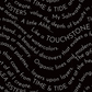 Writing on the Wall Script Black quilting cotton by FreeSpirit Fabrics -- close-up of bold black ground with free-flowing white script text in curved waves including Sea Sisters, Time and Tide, Touchstone, and coastal-inspired phrases -- 100% cotton, 43-44" wide