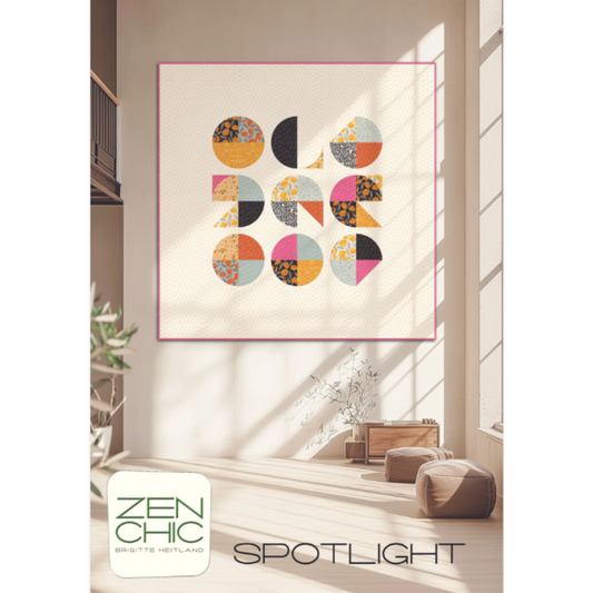 Spotlight quilt pattern by Brigitte Heitland for Zen Chic — bold circle blocks in cream, pink, black, and orange displayed as wall art in a modern living room