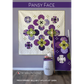 Pansy Face quilt pattern cover by Robin Pickens — purple and green pansy bloom blocks set on point, displayed as wall art with a purple lap quilt on a ladder