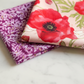 Superbloom fabric by Robin Pickens for Moda Fabrics – folded charm squares showing large red poppy print and purple floral blender